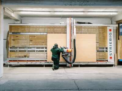 Ein Arbeiter bedient eine moderne Maschine zur Bearbeitung von Sperrholz bei Wölbert in Dortmund. | © Wölbert