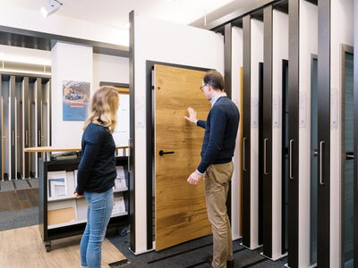 Ein Kunde betrachtet eine massive Holztür im Sperrholz Wölbert Showroom in Dortmund. | © Wölbert