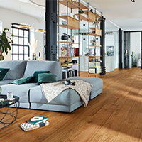 Moderne Wohnung in Dortmund mit Holzfußboden, gemütlichem Sofa und stilvollen Dekoren | © Sperrholz Wölbert